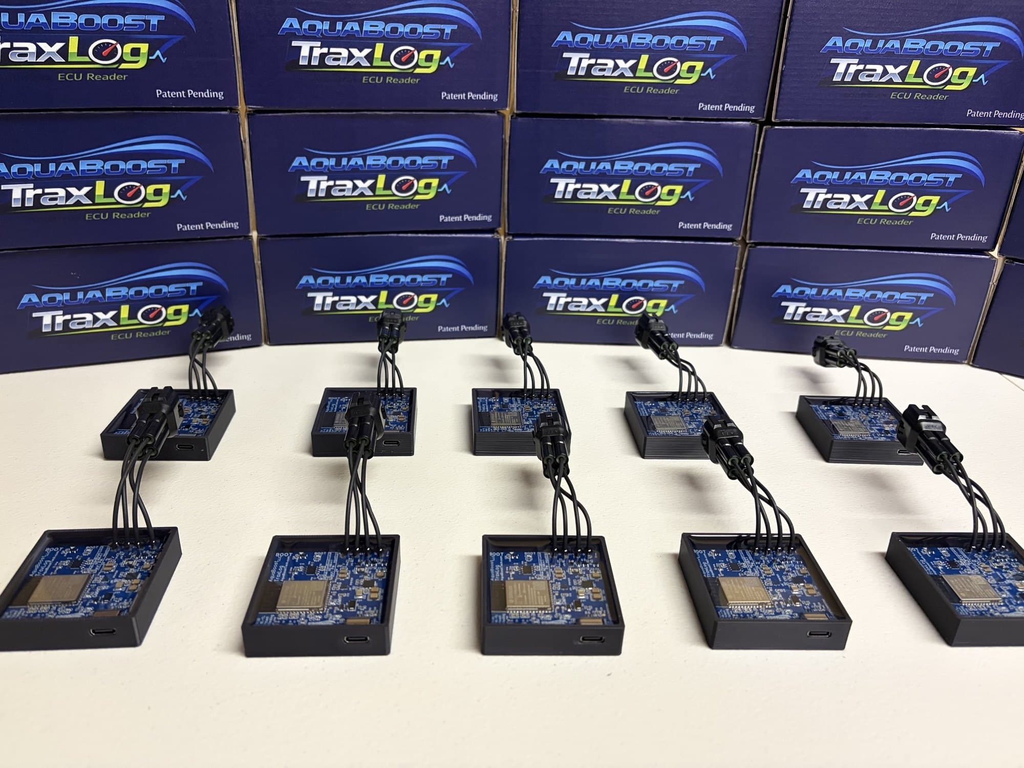 Assembled AquaBoost TraxLog modules in front of their retail boxes, from the current production run